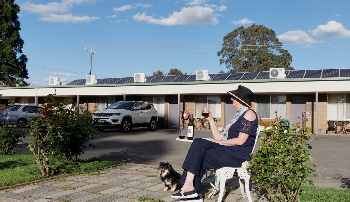 Women enoying a drink with her pet in carvan park